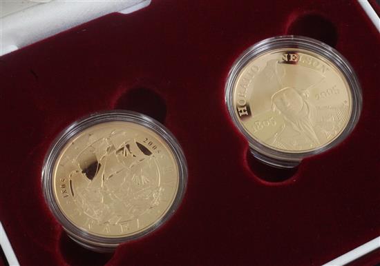 A cased Royal Mint 2005 Horatio Nelson gold proof commemorative crown and a 2005 Bottle of Trafalgar gold proof commemorative crown